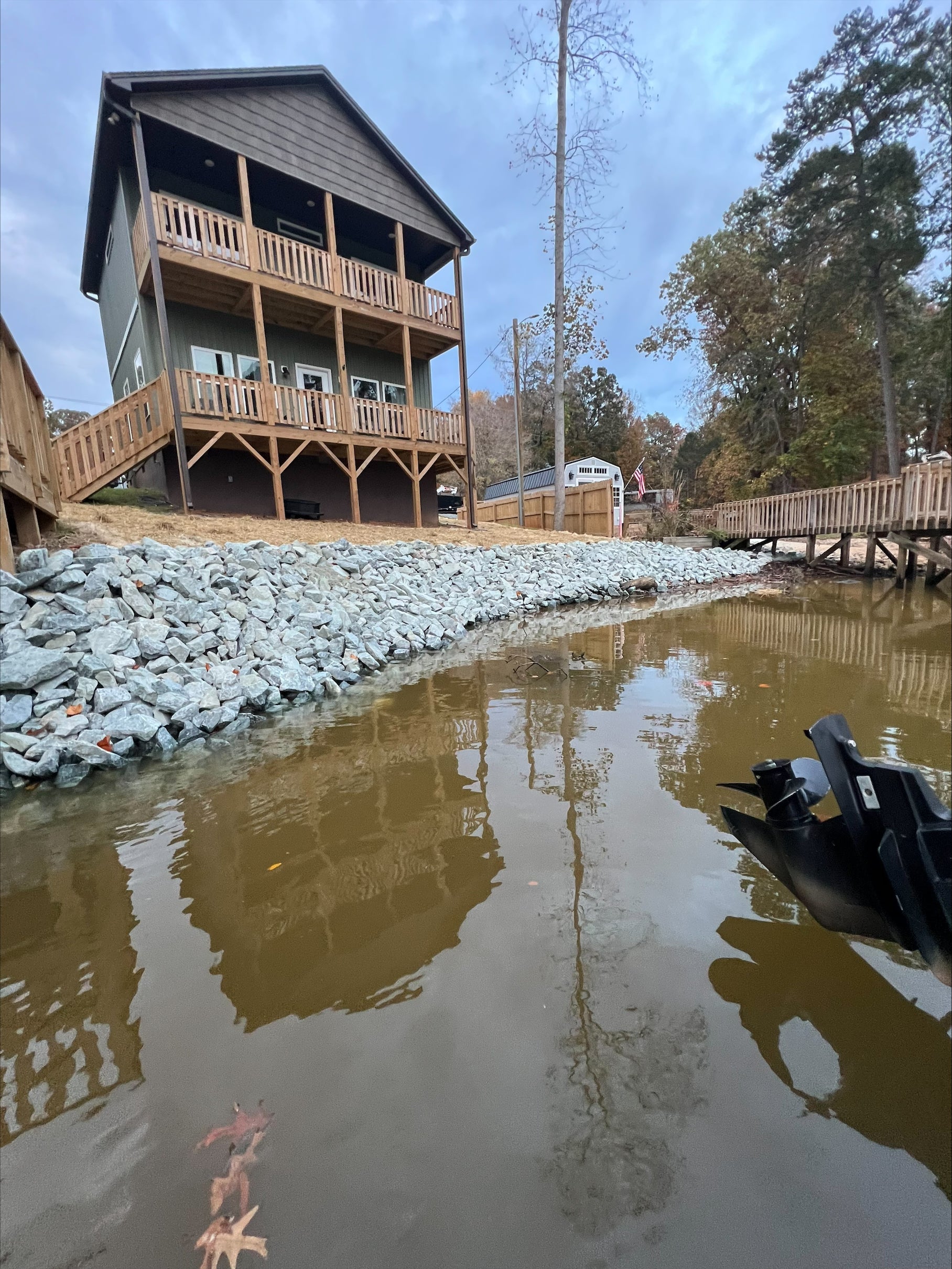 A black pipe snaking through a shallow, narrow trench of reddish-brown earth.